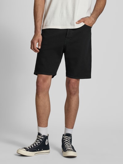 Männermodel trägt Relaxed Fit Jeansshorts Modell 'TONY' von Jack & Jones, Baumwoll-Elasthan-Mix, Eingrifftaschen, Ganzkörperansicht von vorne. Bundweite bei Größe M: 42 cm, Innenbeinlänge: 21 cm.