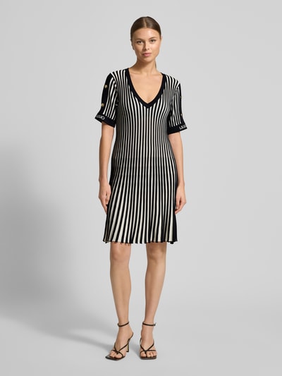 Frauenmodel trägt Minikleid mit gerippten Abschlüssen von LIU JO SPORT, Viskose-Mix, tailliert, V-Ausschnitt, Streifenmuster, Ganzkörperansicht von vorne.