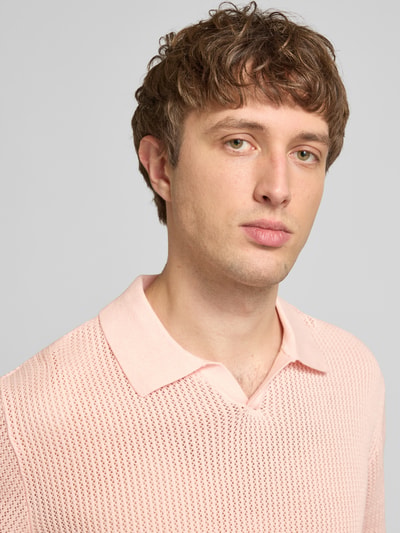 Männermodel trägt Regular Fit Strick-Poloshirt Modell 'CASSIS' van Jack & Jones in lichtroze, pure katoen, V-hals, detailopname bovenlichaam.