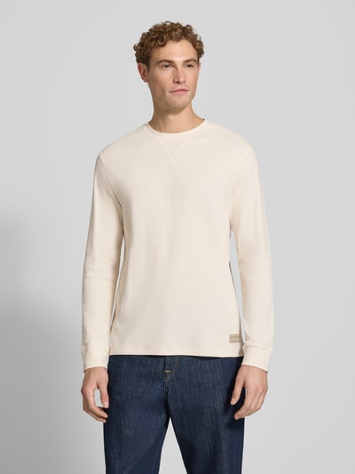 Männermodel trägt Regular Fit Sweatshirt aus reiner Baumwolle von Scotch & Soda in Beige mit Strukturmuster und Logo-Patch, Ganzkörperansicht von vorne. Rückenlänge bei Größe M: 70 cm.