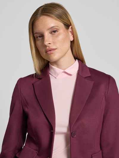 Frauenmodel trägt Slim Fit Blazer mit Pattentaschen von Marc Cain, Material-Mix mit Baumwoll-Anteil, Reverskragen, Knopfverschluss, Nahaufnahme Oberkörper. Rückenlänge bei Größe 36: 54 cm, Brustweite: 35 cm, Ärmellänge: 63 cm.