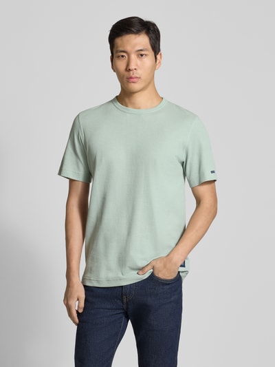 Männermodel trägt Regular Fit T-Shirt aus Baumwoll-Mix von Tom Tailor in Optik: Unifarben und Piqué-Struktur, Ganzkörperansicht von vorne.