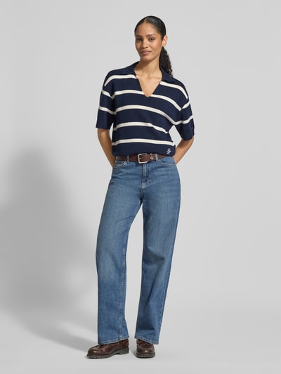 Frauenmodel trägt Regular Fit Pullover aus reiner Baumwolle von Tommy Hilfiger mit Navy-Weiß Streifen, Logo-Stitching, Feinstrick, Ganzkörperansicht von vorne.
