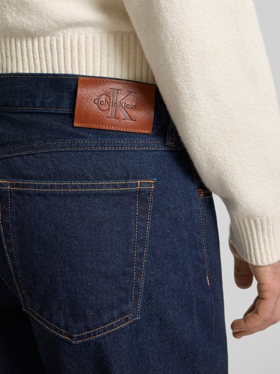 Mannenmodel draagt 'Jeans mit 5-Pocket-Design' van Calvin Klein Jeans, donkerblauw, rechte pasvorm, detailopname achterkant.