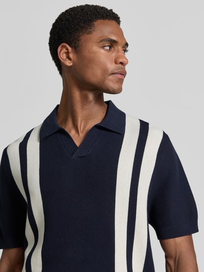 Männermodel trägt Regular Fit Poloshirt in Strick-Optik von MCNEAL in Dunkelblau mit weißen Streifen, Reine Baumwolle, Nahaufnahme Oberkörper.
