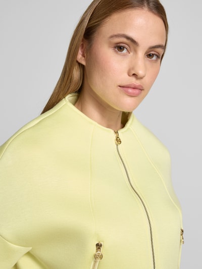 Frauenmodel trägt Jacke mit 1/2-Arm und Reißverschlusstaschen von Rinascimento in zartem Gelb, Viskose-Mix, Nahaufnahme Oberkörper.