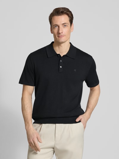 Männermodel trägt Regular Fit Poloshirt in Strick-Optik Modell 'Supima' von CK Calvin Klein, schwarz, reine Baumwolle, Nahaufnahme Oberkörper.