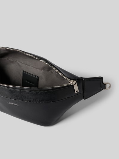 Produktfoto, Waistbag in Leder-Optik Modell 'Raised' von Calvin Klein in Schwarz mit silbernem Reißverschluss, Hauptfach und Logo-Detail