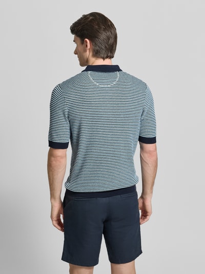Männermodel trägt Slim Fit Poloshirt in Strick-Optik mit Leinen-Anteil von Brax, Baumwoll-Mix, elastische Abschlüsse, Rückenlänge 67 cm, Ganzkörperansicht Rückansicht.