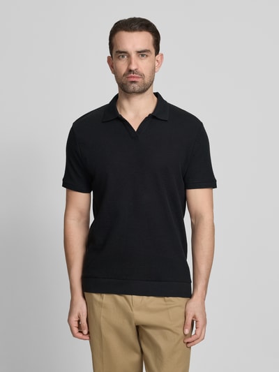 Männermodel trägt Comfort Fit Poloshirt mit V-Ausschnitt von Lindbergh in Schwarz, Strukturmuster, Reine Baumwolle, Label-Detail, Ganzkörperansicht von vorne. Rückenlänge bei Größe M: 68 cm.