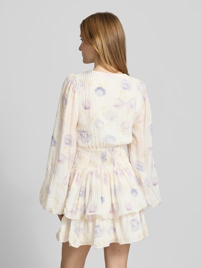 Frauenmodel trägt Minikleid aus Viskose-Mix mit V-Ausschnitt von Gina Tricot, Floraler-Print, Tailliert, Langärmelig, Raffung, Ganzkörperansicht Rückansicht.