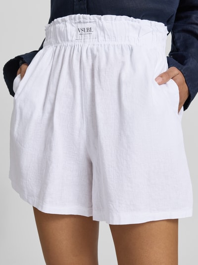 Frauenmodel trägt Regular Fit Stoffshorts aus Leinen-Baumwoll-Mix Modell 'MILLIE' von VILLA SOPHIE in Weiß mit elastischem Bund und Eingrifftaschen, Nahaufnahme Oberkörper, Fokus auf Textur und Allover-Muster.