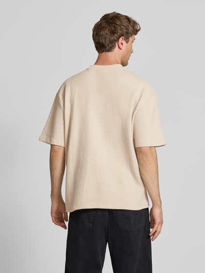 Männermodel trägt Oversized T-Shirt mit Strukturmuster und Label-Stitching von Pegador aus Reine Baumwolle, Rückenlänge 70 cm, Ganzkörperansicht Rückansicht.