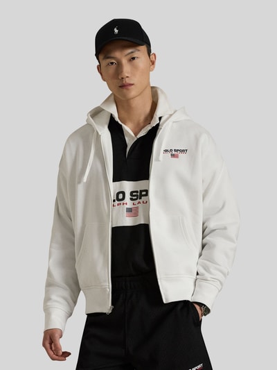 Männermodel trägt Relaxed Fit Sweatjacke aus Baumwoll-Mix von Polo Ralph Lauren, unifarben weiß, Reißverschluss, Label-Print, Ganzkörperansicht von vorne.