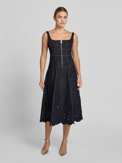 Frauenmodel trägt Knielanges Kleid in Denim-Optik von Self-Portrait aus Baumwoll-Mix, tailliert, ärmellos, Reißverschluss, Loch-Stickerei, Ganzkörperansicht von vorne.