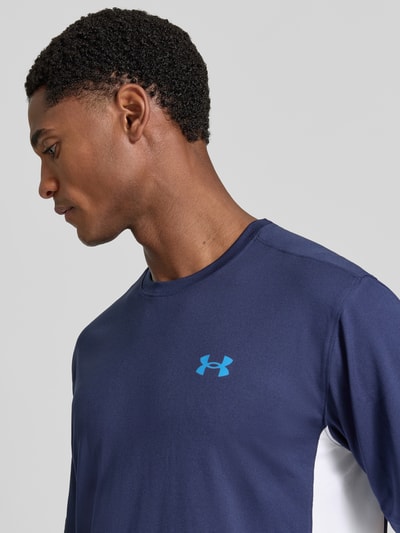 Männermodel trägt dunkelblaues Regular Fit Sport-T-Shirt mit Label-Print van Under Armour, blauwe logo op de borst, Nahaufnahme Oberkörper.