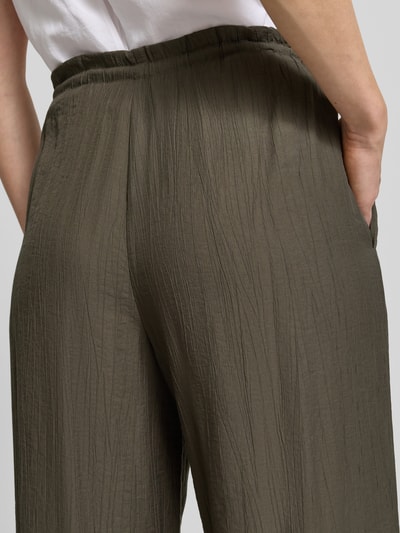 Frauenmodel trägt Wide Fit Stoffhose aus Viskose-Mix Modell 'Marou' von OPUS mit Strukturmuster, elastischer Bund, Nahaufnahme Rückansicht, Bundweite 113 cm, Innenbeinlänge 78 cm, Größe 36.