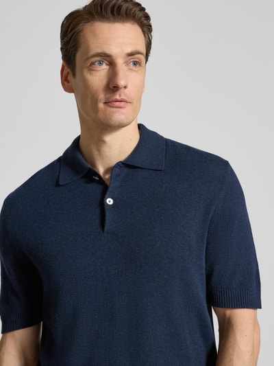 Männermodel trägt Slim Fit Poloshirt mit Kaschmir-Anteil von FTC Cashmere in dunkelblauem Katoenmix mit polokraag, knoopsluiting und 1/2-mouwen, Nahaufnahme Oberkörper.
