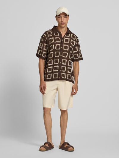 Männermodel trägt Regular Fit Freizeithemd im Allover-Look Modell 'FABIAN' von Redefined Rebel mit Polokragen und Knopfleiste, braun-beige gemustert, Ganzkörperansicht von vorne. Rückenlänge bei Größe M: 70 cm, Schulterbreite 43 cm, Ärmellänge 28 cm.