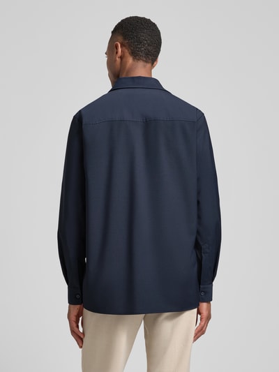 Männermodel trägt Relaxed Fit Hemdjacke mit Schurwoll-Anteil Model 'Arion' von DIGEL in Dunkelblau, Rückenansicht, Ganzkörperansicht Rückansicht. Elastischer Material-Mix, Brusttaschen, Umlegekragen, Sportmanschetten, Rückenlänge bei Größe M 76 cm.