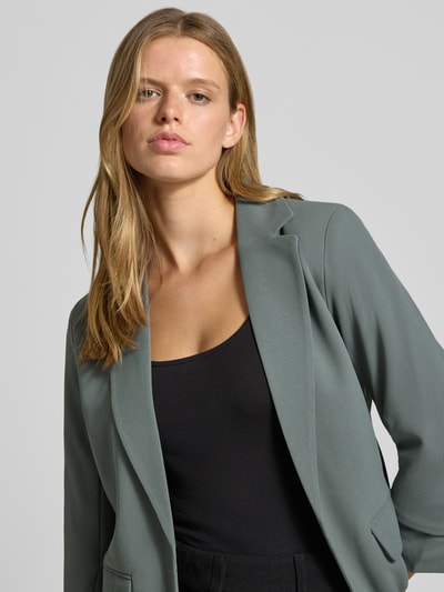 Frauenmodel trägt Regular Fit Longblazer mit 3/4-Arm Modell 'KALINA' von ONLY in mattgrün, glatte Textur, Nahaufnahme Oberkörper, Damen Longblazer von ONLY.