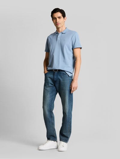 Männermodel trägt Regular Fit Poloshirt aus reiner Baumwolle von Tom Tailor in Optik: Unifarben, Piqué-Struktur, Ganzkörperansicht von vorne.