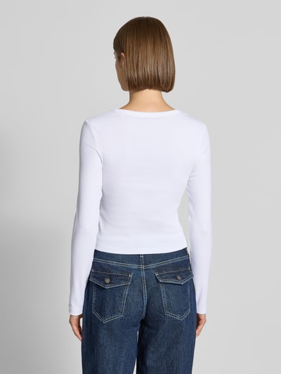 Frauenmodel trägt Slim Fit Longsleeve aus Baumwoll-Mix von GUESS in Weiß und Blau, strukturierte Stoffoptik, Ganzkörperansicht Rückansicht. Damen Longsleeve von GUESS Jeans, elastischer Baumwoll-Mix, durchgängige Knopfleiste, Logo-Stitching, Rückenlänge bei Größe S 44 cm.