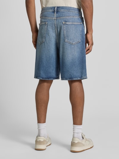 Männermodel trägt Bermudas im 5-Pocket-Design von GAP aus Baumwoll-Lyocell-Mix, Loose-Fit, mittleres Jeansblau, Ganzkörperansicht Rückansicht.