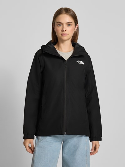 Frauenmodel trägt Regular Fit Funktionsjacke mit Logo-Print Modell 'Quest Mono' von The North Face in Schwarz, glatte Oberfläche, Ganzkörperansicht von vorne, Damen Funktionsjacken Kontext integriert.