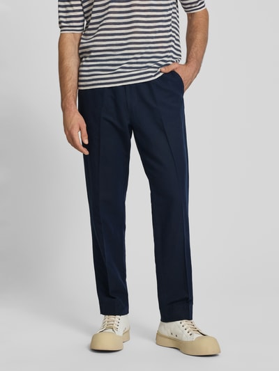 Mannenmodel draagt Straight Fit broek uit mix van linnen en katoen met Persplooien, steekzakken en elastische band van Filippa K, Ganzkörperansicht von vorne. Context: Heren broek van Filippa K, mix van linnen en katoen, straight fit, persplooien, steek- en achterzakken, elastische band, binnenbeenlengte maat 50: 80 cm, bandwijdte maat 50: 42 cm.