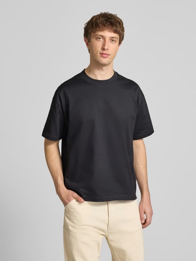 Männermodel trägt Boxy Fit T-Shirt aus reiner Baumwolle von Marc O'Polo Denim, unifarben, kurzarm, Rundhals, Ganzkörperansicht von vorne.