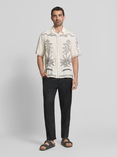 Männermodel trägt Regular Fit vrijetijdsoverhemd met kentkraag en stitchings van Scotch & Soda, puur katoen, knoopsluiting, crèmekleurig met zwarte details, ruglengte maat M 73 cm, schouderbreedte 49 cm, mouwlengte 28 cm, hele lichaam voorkant.