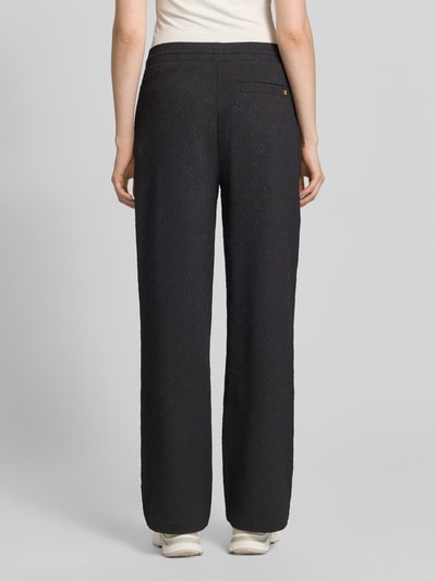 Frauenmodel trägt Regular Fit Sweatpants mit Allover-Muster Modell 'NAYENE' von HUGO, Optik:Allover-Muster, Materialverarbeitung: Sweat, Bundabschluss: elastisch, Gesäßtasche, seitliche Eingrifftaschen, Label-Stitching-Applikation, Ganzkörperansicht Rückansicht.