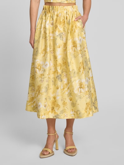 Frauenmodel trägt High Waist Midirock aus Lyocell-Mix Modell 'LEMON' von YAS, Damen A-Linie mit Drapierungen, gelb, florales Muster, Eingrifftasche, Nahaufnahme Unterkörper, Vorderansicht.