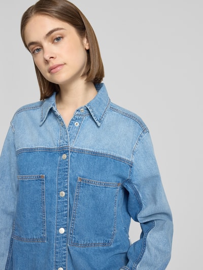 Frauenmodel trägt Relaxed Fit Jeansbluse aus Baumwoll-Ananas-Mix von Marc O'Polo Denim in blauem Denim mit Brusttaschen, Nahaufnahme Oberkörper.