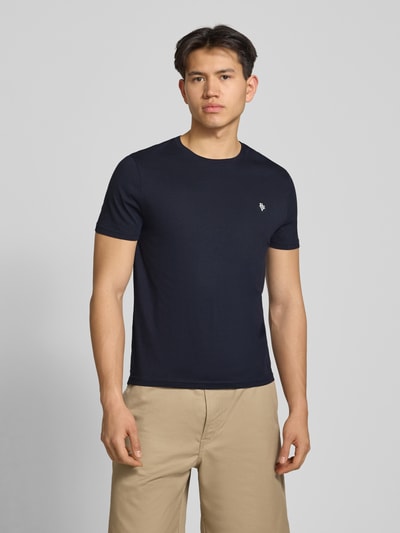 Männermodel trägt Basic Slim Fit T-Shirt mit Flock-Logo auf der Brust von REVIEW, dunkelblau, schlichte Struktur, Ganzkörperansicht von vorne.