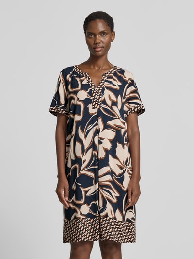 Frauenmodel trägt A-Linien Freizeitkleid aus reiner Viskose von Betty Barclay in Dunkelblau und Beige mit floralem Muster, Ganzkörperansicht von vorne. Damen Freizeitkleid von Betty Barclay.
