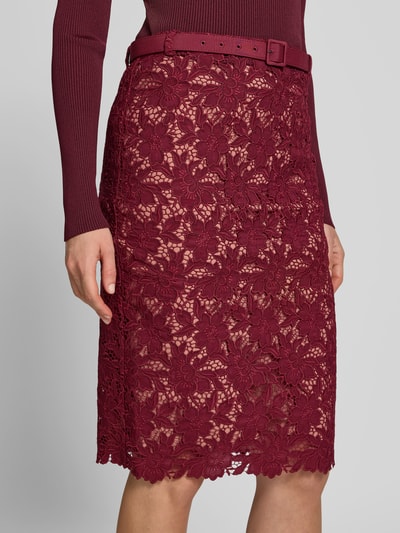 Frauenmodel trägt Slim Fit Rock mit Allover-Spitzenbesatz von Self-Portrait, knielang, abnehmbarer Gürtel, Nahaufnahme Oberkörper.