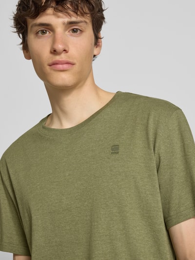 Männermodel trägt T-Shirt mit Logo und Rundhalsausschnitt von G-Star Raw in Grün aus Reine Baumwolle, Regular-Fit, Nahaufnahme Oberkörper.