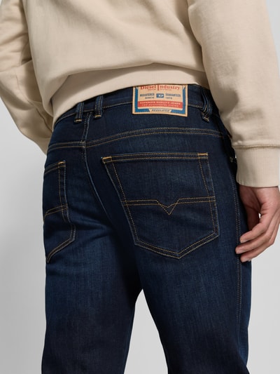 Männermodel trägt Straight Fit Jeans aus Viskose-Mix von Diesel in Dunkelblau mit 5-Pocket-Design und Logo-Detail, Nahaufnahme Rückansicht. Innenbeinlänge 83 cm, Bundweite 43 cm bei Größe 32/32.