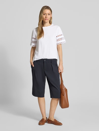 Frauenmodel trägt Damen T-Shirt mit 1/2-Arm Modell 'APE' von EMME aus reiner Baumwolle, taillierte Passform, Spitzenbesatz, Rundhalsausschnitt, Rückenlänge bei Größe S 56 cm, weiße Farbe, glatte Textur, Ganzkörperansicht von vorne.