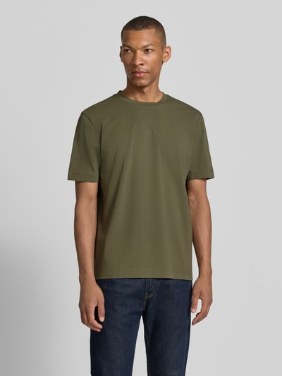 Męski model nosi Regular Fit T-Shirt aus Baumwoll-Mix Modell 'TCHUP' od BOSS Orange, kolor oliwkowy, gładka faktura, Ganzkörperansicht von vorne.