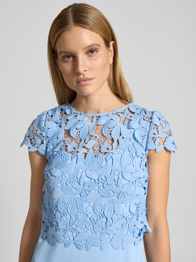Frauenmodel trägt Knielanges Cocktailkleid im 2-in-1-Look von Christian Berg Cocktail, hellblau, Spitze, Rundhalsausschnitt, Nahaufnahme Oberkörper.