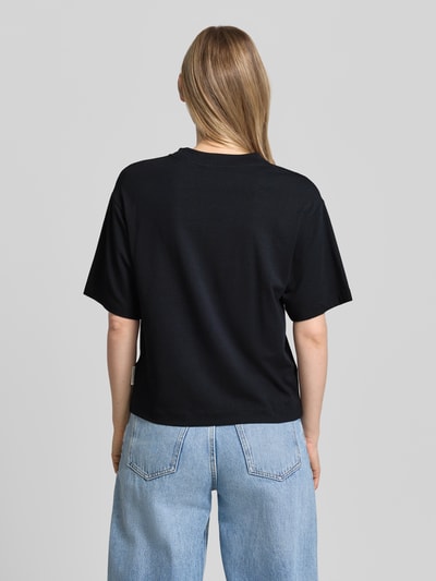 Frauenmodel trägt Regular-Fit T-Shirt aus Baumwoll-Mix von Marc O'Polo in Schwarz, kombiniert mit blauen Jeans, Damen T-Shirt, Ganzkörperansicht Rückansicht.