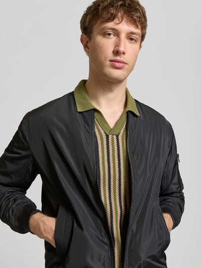 Mężczyzna nosi Regular Fit Koszulkę polo w imitacji dzianiny Model 'Carly' od Blend, z krótkim rękawem, kołnierzykiem polo, bawełna, kolor oliwkowy, krój regular fit, długość tyłu w rozmiarze M: 72 cm, widok na górną część ciała z przodu.