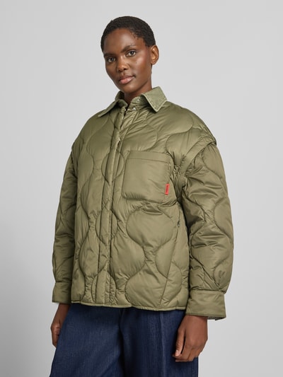 Frauenmodel trägt olivgrüne Steppjacke mit Umlegekragen Modell 'MCOGIUGNIO' von MAX&Co., wattierte Optik, Ganzkörperansicht von vorne. Damen Steppjacke.