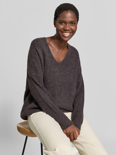 Kobiece modelka nosi sweter z dzianiny z mieszanki wełny i alpaki MOS MOSH Strickpullover aus Woll-Mix mit V-Ausschnitt Model 'THORA', krój regular fit, dekolt w serek, długość tyłu w rozmiarze S: 82 cm, długość rękawów w rozmiarze S: 46 cm, ciemnofioletowy, miękka tekstura. Ujęcie: z przodu, zbliżenie górnej części ciała.