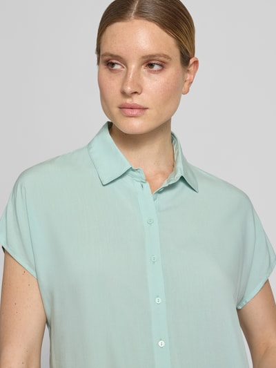 Frauenmodel trägt Relaxed Fit Bluse aus Reine Viskose von Christian Berg Woman in Hellgrün mit Hemdblusenkragen und Knopfleiste, Nahaufnahme Oberkörper.