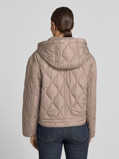 Männermodel trägt Steppjacke mit Kapuze von White Label w kolorze beżowym, wyraźna tekstura pikowania, prosty krój, Ganzkörperansicht Rückansicht. Długość tyłu w rozmiarze 36: 58 cm, szerokość ramion w rozmiarze 36: 51 cm, szerokość klatki piersiowej w rozmiarze 36: 55 cm, długość rękawów w rozmiarze 36: 58 cm.
