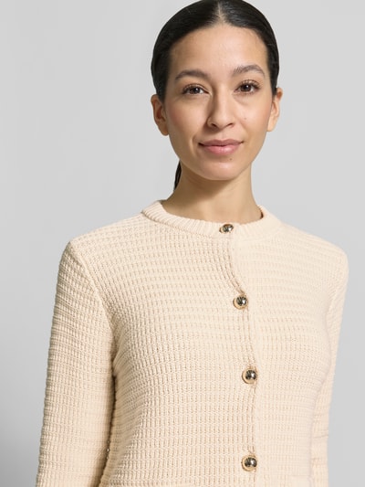 Frauenmodel trägt Regular Fit Strickjacke aus Baumwoll-Mix Modell 'VODKA' von Weekend Max Mara mit Rundhals, Knopfleiste, gestreiftem Strick in Creme, Nahaufnahme Oberkörper.